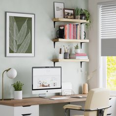 a desk with a computer on top of it next to a chair and bookshelf