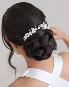 a woman wearing a wedding hair comb with flowers on it's back and side