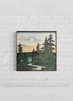 a painting hanging on the wall above a white brick wall with a river and trees