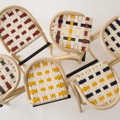 four chairs made out of woven material with different colors and shapes on the backrests