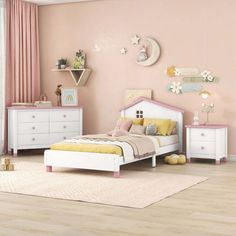 a child's bedroom with pink walls and white furniture