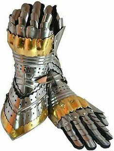 a pair of gloves made out of silver and gold colored metal armor with spikes on the fingers