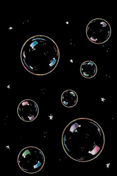 soap bubbles floating in the air on a black background with stars and snowflakes