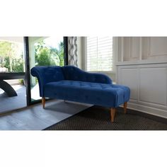 a blue chaise lounge chair in front of a window