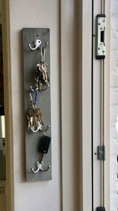 there is a key holder on the wall with keys in it and an open door