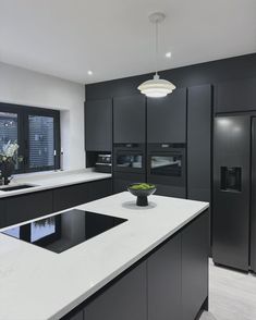 a modern kitchen with black cabinets and white counter tops, along with a center island