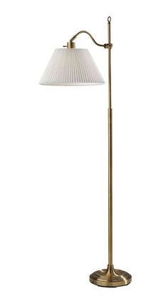 an antique brass floor lamp with a white shade