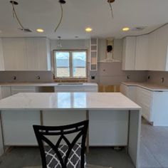 an empty kitchen with white cabinets and counter tops