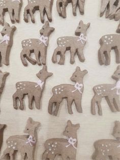 a group of small brown deer shaped cookies on top of a white table cloth covered in icing