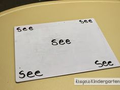 a sign that says see and see on the side of a table with black letters