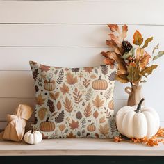 decorative fall leaves and pumpkins sit on a shelf