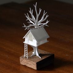 a white tree house on top of a wooden table