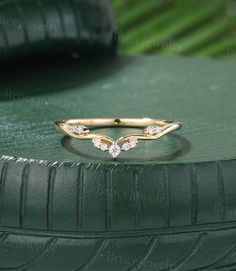 a gold ring with three diamonds sitting on top of a green tire treading surface