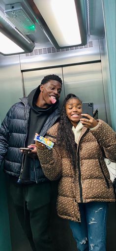 two people taking a selfie in an elevator