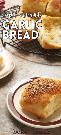 garlic bread is on a plate next to some rolls