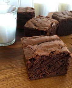 some brownies are sitting on a table next to a glass of milk