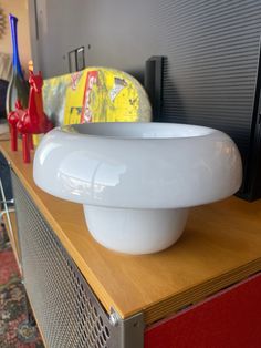 a white bowl sitting on top of a wooden table in front of a television screen