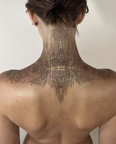 the back of a woman's neck is covered with intricate tattoos, which are all over her body