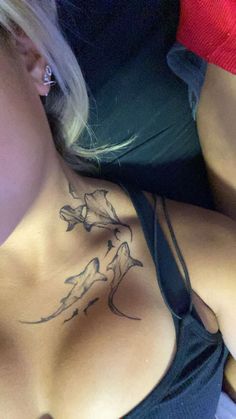 a woman laying down with a tattoo on her chest and arm behind her back,