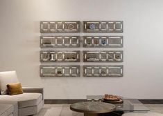 a living room filled with white furniture and lots of shelves on the wall above it