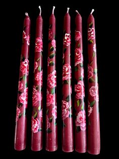 four candles with pink flowers on them