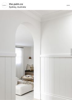 an arch leading into a living room with white walls