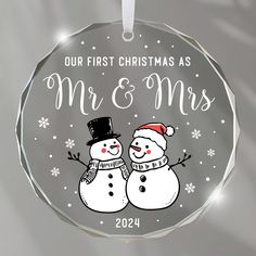 a glass ornament with two snowmen on it's side and the words, our first christmas as mr & mrs