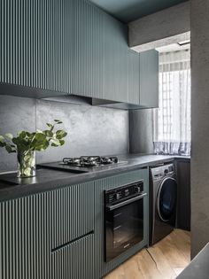 a kitchen with a stove top oven sitting next to a washer and dryer