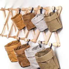 several buckets hanging on a clothes rack with wooden pegs attached to the wall