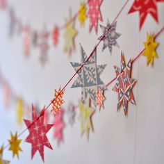 colorful paper stars are hanging from a string