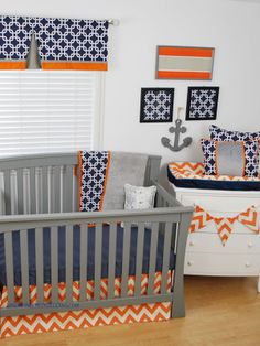 a baby's room is decorated in orange, blue and gray with an anchor theme