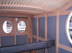 the inside of a house with wood paneling on the walls and round windows in the wall