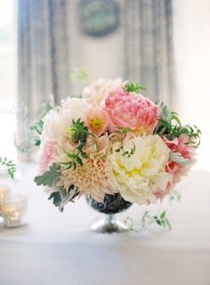 a vase filled with pink and white flowers on top of a table