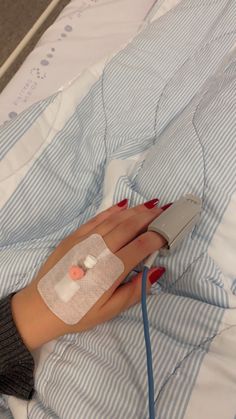 a woman with bandages on her arm laying in bed next to an electronic device that is plugged into her wrist