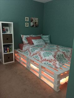 a bed made out of pallets with lights underneath it