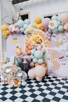 a table topped with balloons and cake on top of a black and white checkered floor