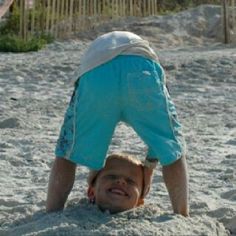 a young boy is playing in the sand