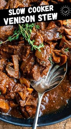 slow cooker venison stew on a black plate with a spoon and fork