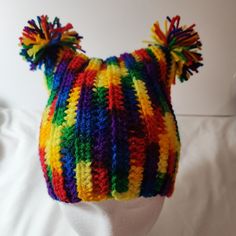 a multicolored knitted hat on top of a white mannequin head