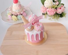 there is a small cake with ice cream and donuts on the table next to flowers