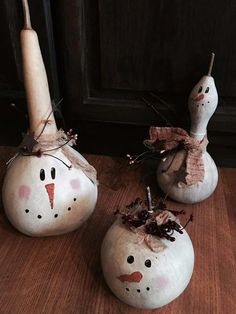 two snowmen sitting on top of wooden floor next to each other