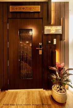 a wooden door with glass panels and a plant in a pot on the floor next to it