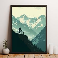 a mountain bike rider is silhouetted against the backdrop of snow - capped mountains and evergreens