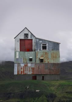 an old barn sits on the side of a hill