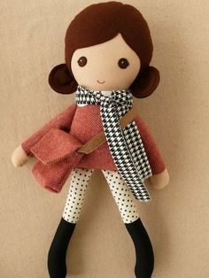 a doll with brown hair wearing a red coat