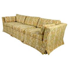 an image of a couch that is in the middle of a white background with yellow and green patterns on it