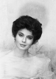 an old black and white photo of a woman with short hair wearing a tulle