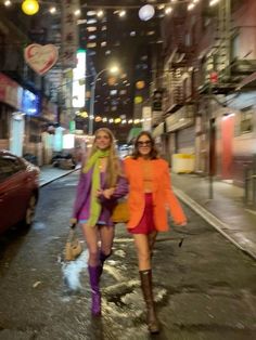 two women walking down the street at night