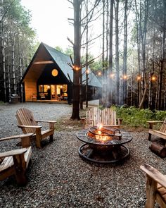 a fire pit sitting in the middle of a forest filled with lots of wood chairs