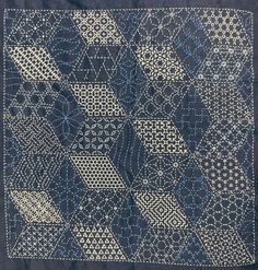 a blue and white quilt with many different designs on it's sides, including an intricate